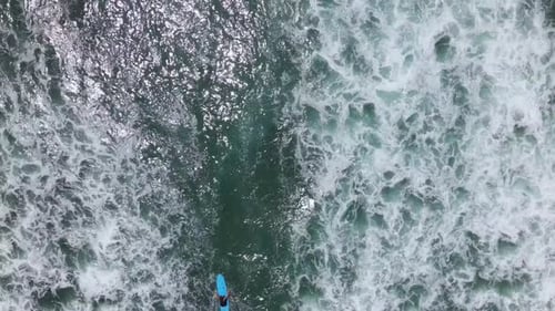 Drone Shot Of Surfer Paddling Through Pacific Ocean 4K