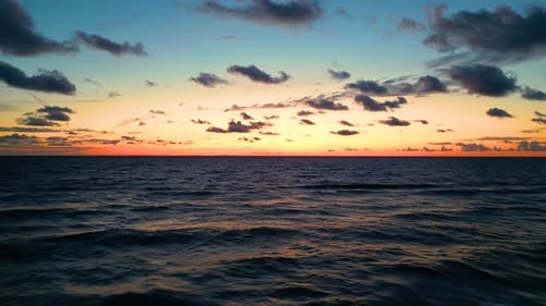 Tropical golden sunset over ocean water slow motion aerial view. Sun setting reflection on seascape.