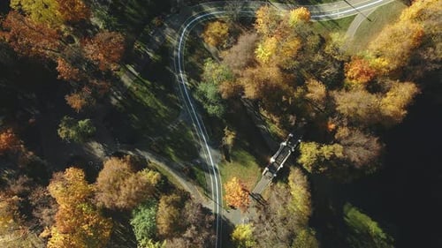 Herbst-Stadtpark. Bäume mit bunten Blättern. Ein Radweg schlängelt sich zwischen den Bäumen. Herbst-Landschaft