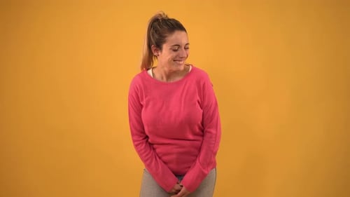 Video of Young Blonde Woman Looking at Camera and Smiling in Color Studio Shot