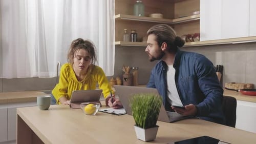 Couple Works with Tech at Home