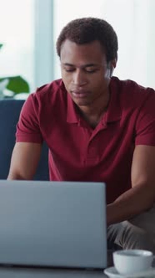 Young Adult Working on Laptop, Drinking Coffee