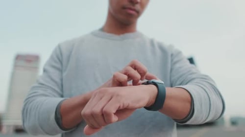 Man Uses Smart Watch in Urban Setting