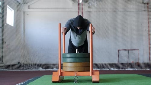 Strong Sportsman is Pushing Heavy Weight Trolley in Gym During Crossfit Workout