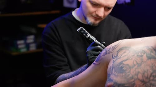 Tattoo Artist Working Intently on Tattoo Design