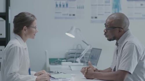 Female Doctor and Patient Talking at the Consultation in Clinic