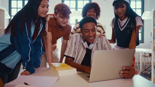 Des étudiants diversifiés étudient ensemble dans une bibliothèque moderne