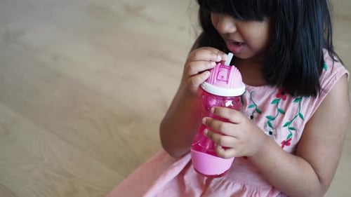 Child Girl Drinking Water Sitting on Sofa
