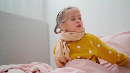 Girl Sits in Bed with Scarf