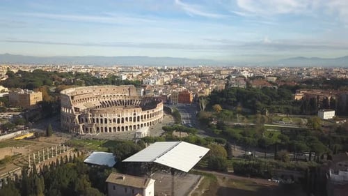 Stunning 4k aerial view of the famous and beautiful Colosseum in Rome while autumn in Italy with bea