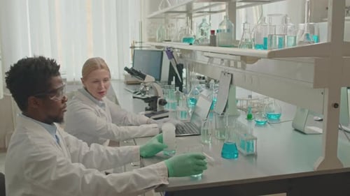 Multiracial Chemists Talking and Making Experiments in Lab