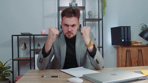 Wütender wütender Mann, der im Home Office arbeitet und zerknittertes Papier wirft mit Nervenzusammenbruch bei