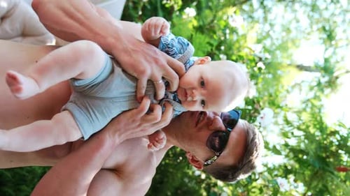 Loving Father Holding Infant in Summer Garden