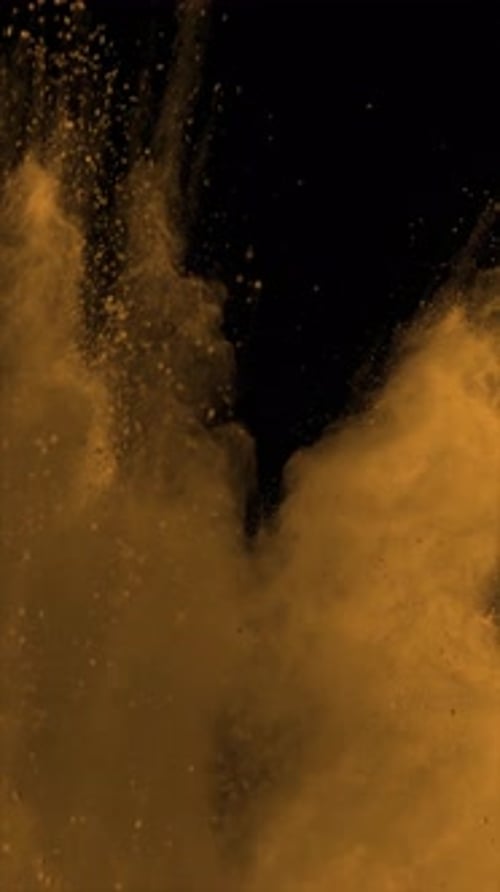 Vídeo vertical de polvo naranja explotando sobre fondo negro