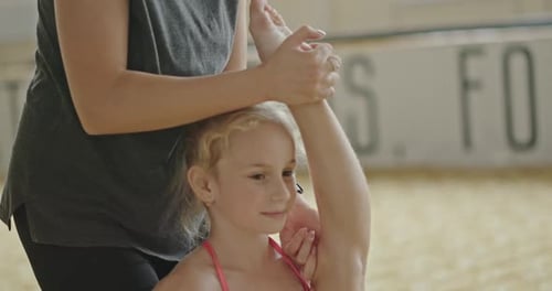 Child Getting Help Stretching Leg Upward