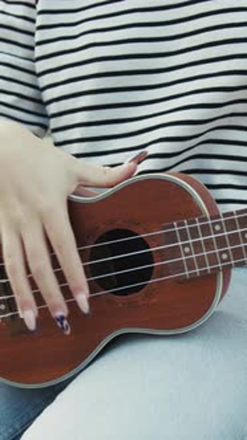 Woman Plays Brown Ukulele