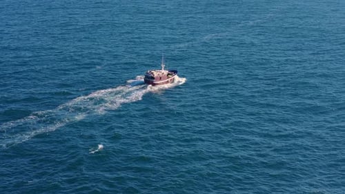 Fishing Boat Navigating Across Ocean In Spain. aerial tracking shot