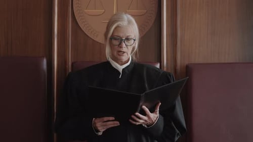 Senior Judge Holding Folder and Passing Decision after Court Hearing