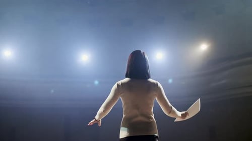 Schauspielerin spielt Monolog auf leerer Bühne mit Drehbuch