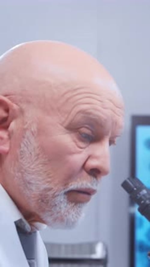 Senior Man Using Microscope in Lab