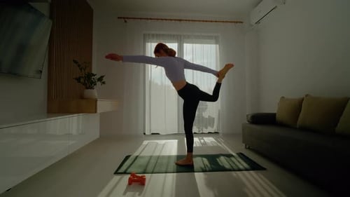 Woman Balancing in Yoga Pose at Home