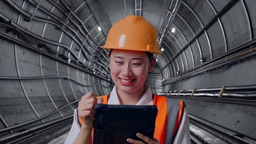 Close Up Of Asian Female Engineer Taking Note On The Tablet In Subway Tunnel