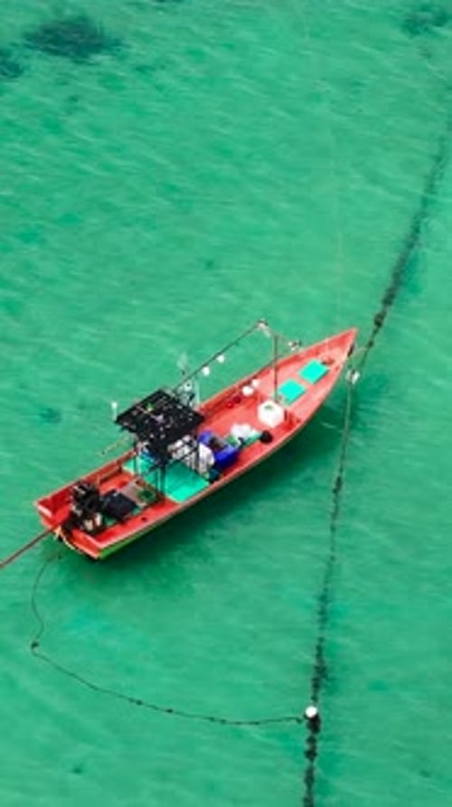 Colorful fishing boat floating on clear turquoise waters
