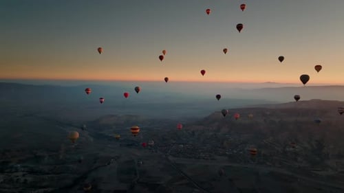 Drone view of hundreds of colorful hot air balloons soaring at sunrise in Cappadocia