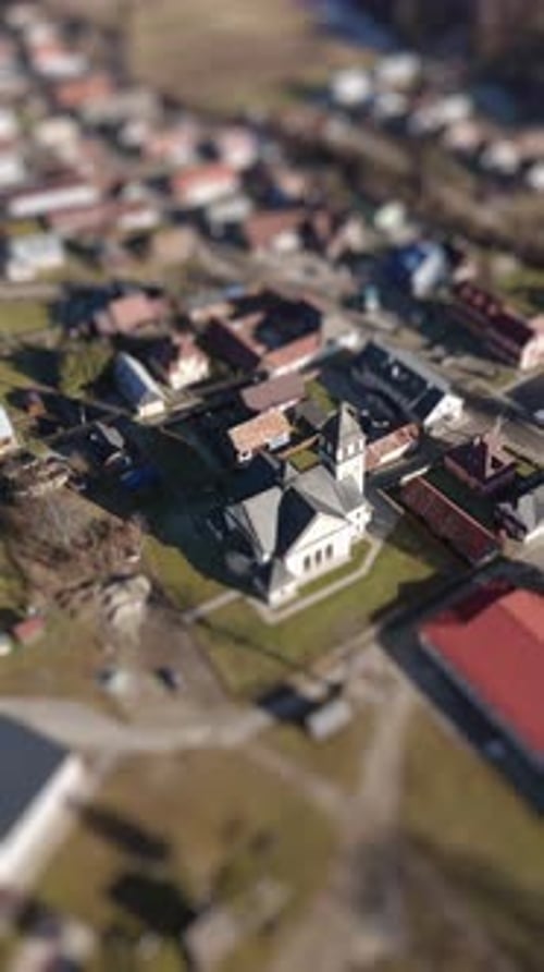 Aerial TiltShift View of a Church in a Quaint Village Landscape with Rotating TopDown Perspective