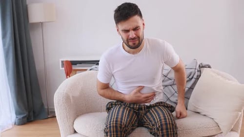 Abdominal pain. Sick man is feeling bad at home.
