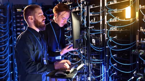 Technicians Working in Server Room Data Center