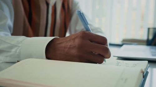 Manos de un hombre de negocios escribiendo un plan y trabajando en una computadora portátil en el escritorio