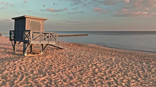 Lifeguard hut on beach at sunrise by Baltic Sea