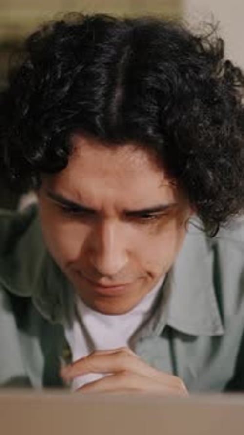 Man Focused on Computer Screen Indoors During the Day