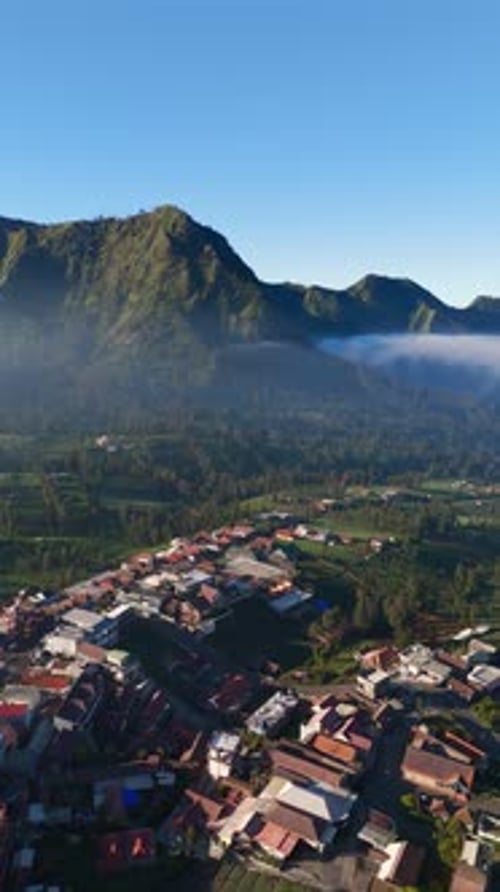 Vertical, aérien : le village de haute altitude de Cemoro Lawang surplombant le mont Bromo et le volcan Semeru