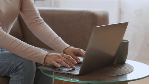 Woman Closing Laptop in an Indoor Home Setting