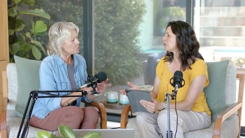 Diverse female hosts using tablet guiding chat, left host counting points for recording with mics