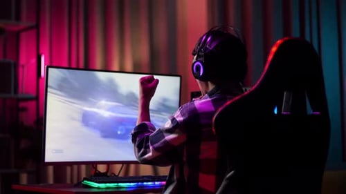 Young Adult Playing Video Game in Dark Room