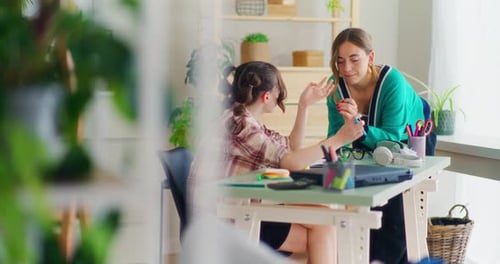 Young Woman Tutoring Child at Home Study Table