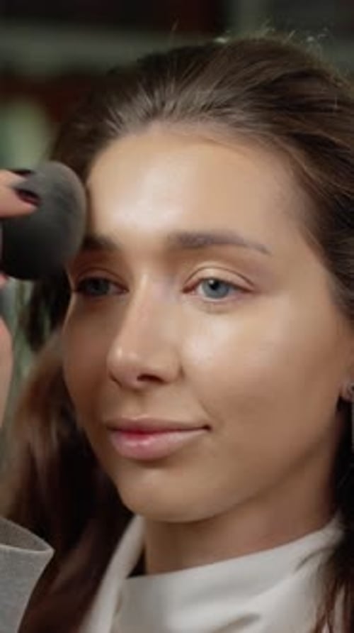 Woman Having Makeup Applied by Makeup Artist