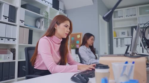 Exhausted Asian young businesswoman overwork late in office workplace.