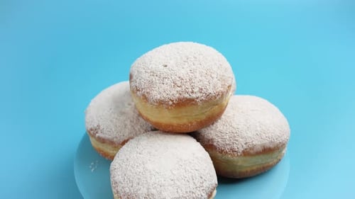 Powdered Sugar Donuts on Blue Plate