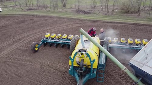 Blue tractor OA working on the field in Ukraine