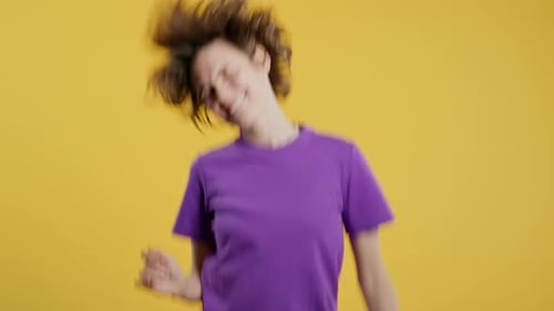 Happy Woman Dancing on Yellow Studio Background Favorite Music Smiling Lady