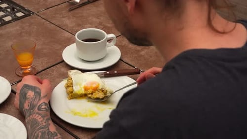 Traditional breakfast with egg and coffee seen over shoulder