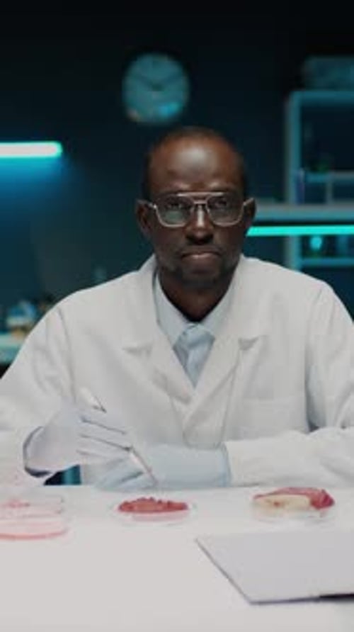 Scientist Examining Lab-Grown Meat Sample in Petri Dish
