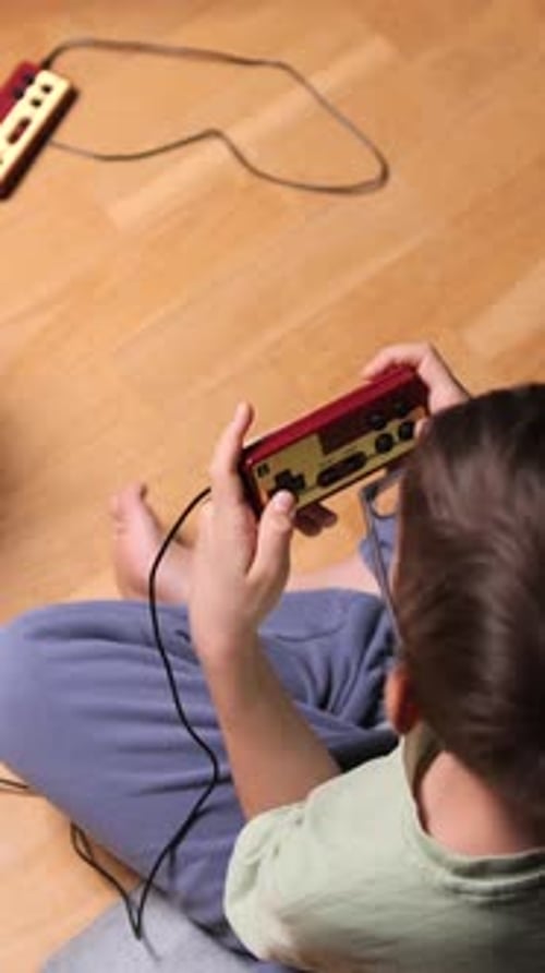 Child Playing Handheld Video Game Indoors