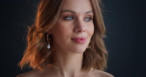 Elegant Woman Posing with Auburn Hair and Earrings