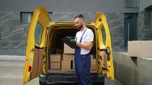 Delivery Man Checking Boxes in Yellow Van