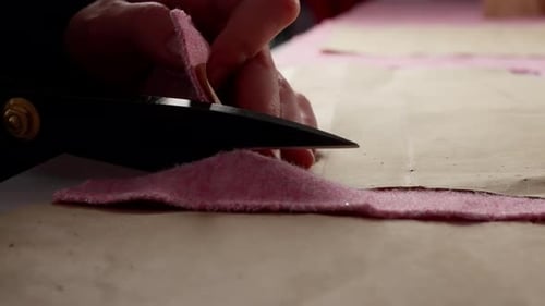 Nahaufnahme von Nähzubehör auf Satinstoff, Nähfäden, Nadeln und Perlen, verteilt auf glattem Satin